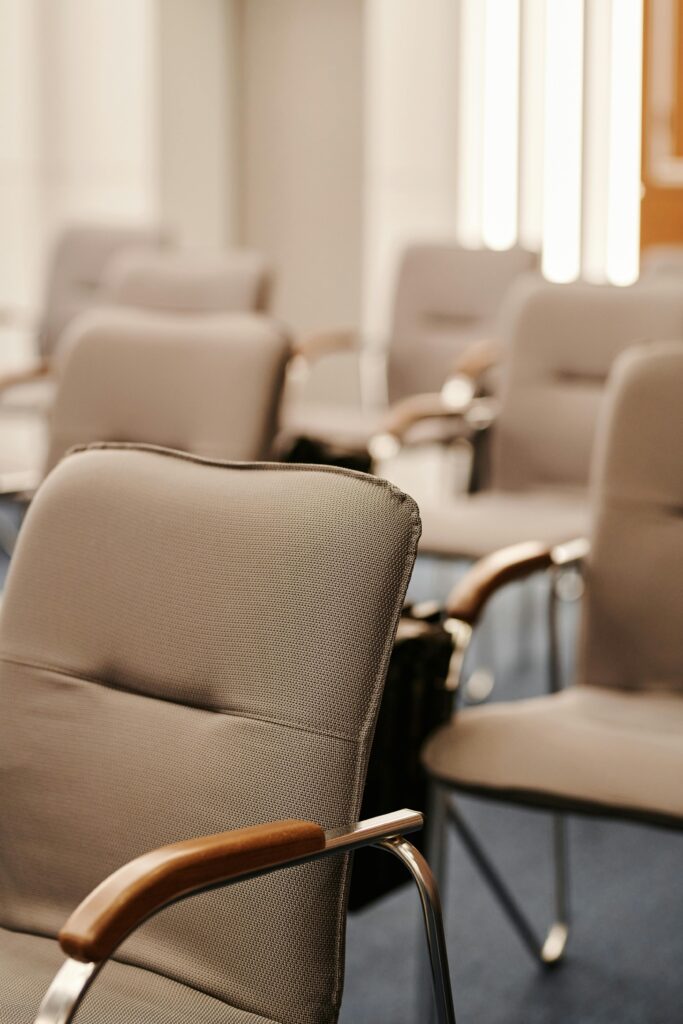 pexels-photo-8354765-8354765 Modern beige armchairs in an empty conference room setting, vertical shot.